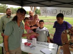 Image of Carol Sutherland holding bug at Alamogordo Farmers' Market Plant Clinic